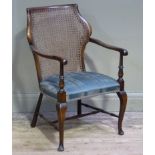 A polished beech bergere caned open armchair with upholstered seat