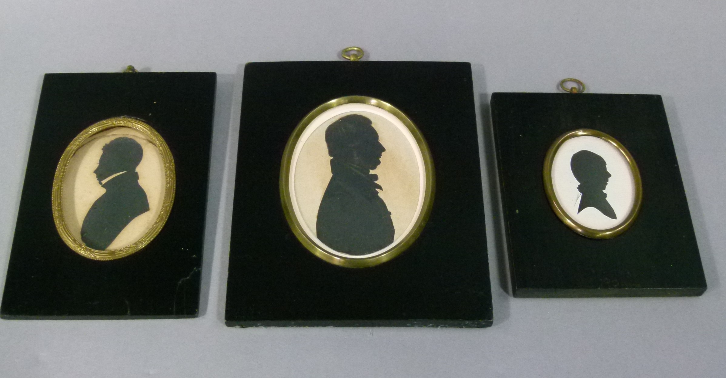 Three 19th century and later silhouettes of two gentleman and a young boy, all in traditional