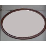 A mahogany framed bevel edged oval wall mirror, 88cm wide