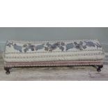 An upholstered long foot stool on squat cabriole legs with pad feet, the top with crewel work