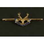 A George V Highlanders regiment tie pin in 15ct gold applied to the centre with a Royal Stag head