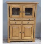 A Siesta oak cabinet, the rectangular oversailing top above a pair of glazed doors, slide, two short