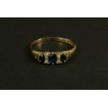 An Edward VII sapphire and diamond ring in 18ct gold, the graduated oval faceted sapphire claw set