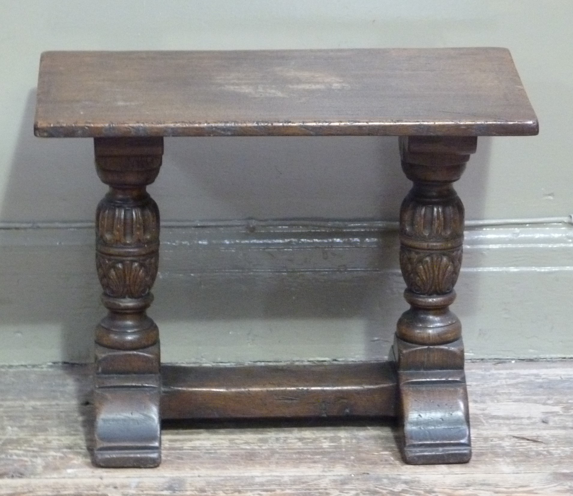 A reproduction small coffee table in late 17th century style the top above fluted leaf carved