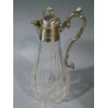 A silver plate mounted cut glass claret jug, the domed lid having a lion and shield finial, shell