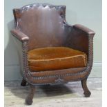 A leather upholstered armchair of tub form with close nailed decoration brown velvet cushion, on