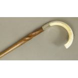 A tapered hardwood walking stick with twisted shaft, silver collar and boar's tusk handle, brass