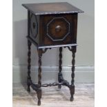 An oak sewing table the shaped square hinged top above a front with octagonal outlined panel