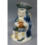 A late 18th/early 19th century pottery Toby jug, the cream ground with blue and yellow glaze (