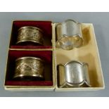 Two pairs of silver napkin rings, one with scalloped rim and engraved H, Sheffield 1916 and an