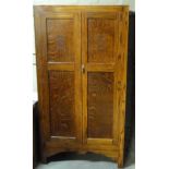 An oak wardrobe with panelled doors, the uppers with fret carved decoration, 172cm high x 92cm wide