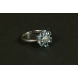 A blue topaz and diamond cluster ring in 9ct white gold set to the centre with four small eight