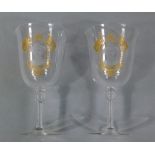 A pair of wine glasses with etched and gilded cartouche enclosing an opaque portrait of Baden Powell