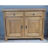 A Siesta oak sideboard, the oversailing rectangular top above two short drawers and a pair of