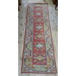 A reproduction Caucasian style bordered runner, 256cm x 82cm