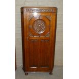 An oak hall wardrobe, the frieze Vitruvian carved, the door deeply panelled circle foliate carved