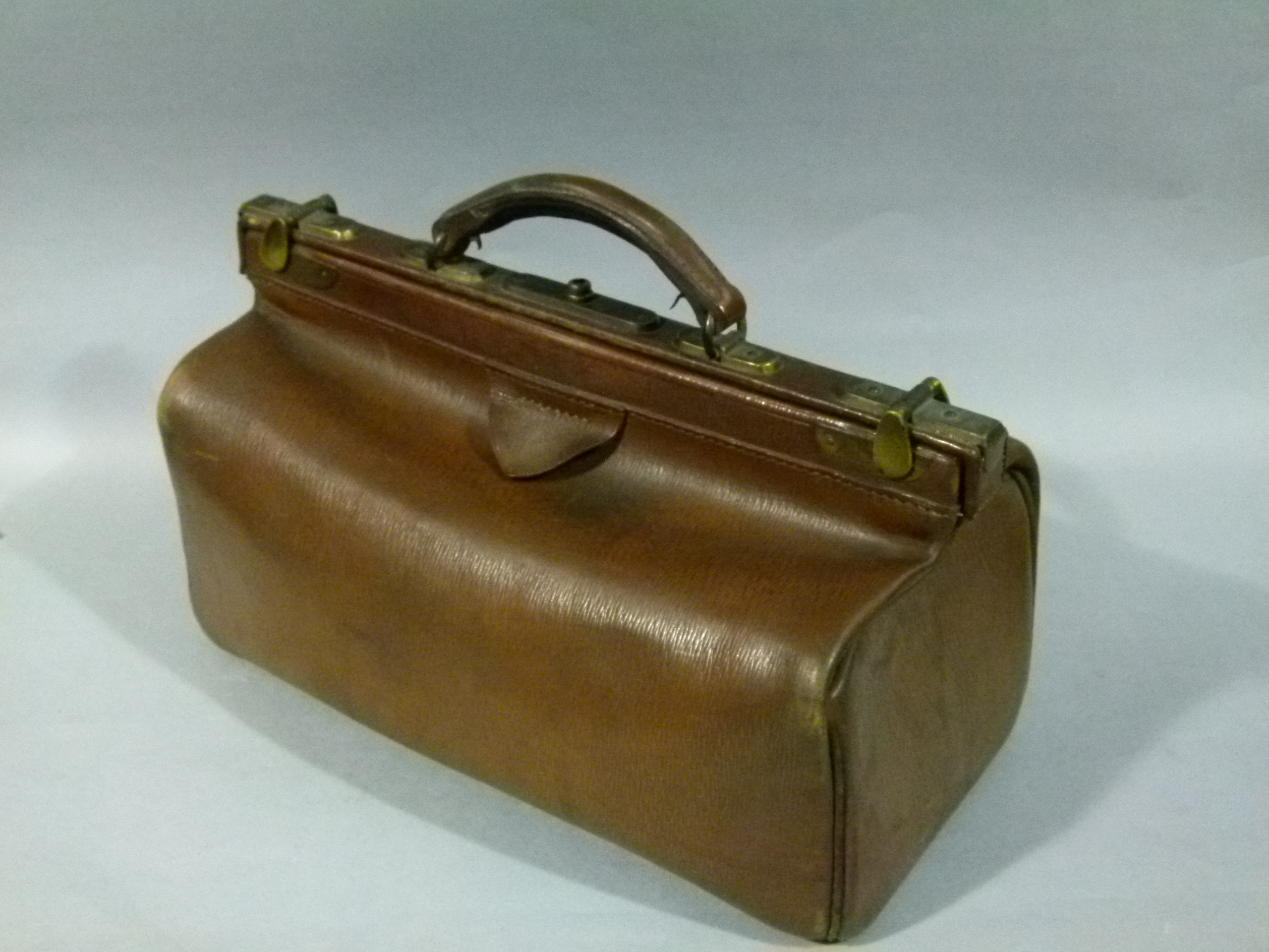 A brown leather Gladstone bag