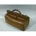 A brown leather Gladstone bag