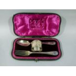 A Christening spoon, fork and napkin ring in velvet lined fitted case, the spoon and fork with shell