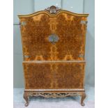 A reproduction burr walnut veneered cocktail cabinet in Queen Anne style, with shell carved