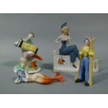 Four 1930's continental potteries figures including a skier, accordion player, mermaid and fashion