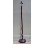 A mahogany turned standard lamp on dished circular base