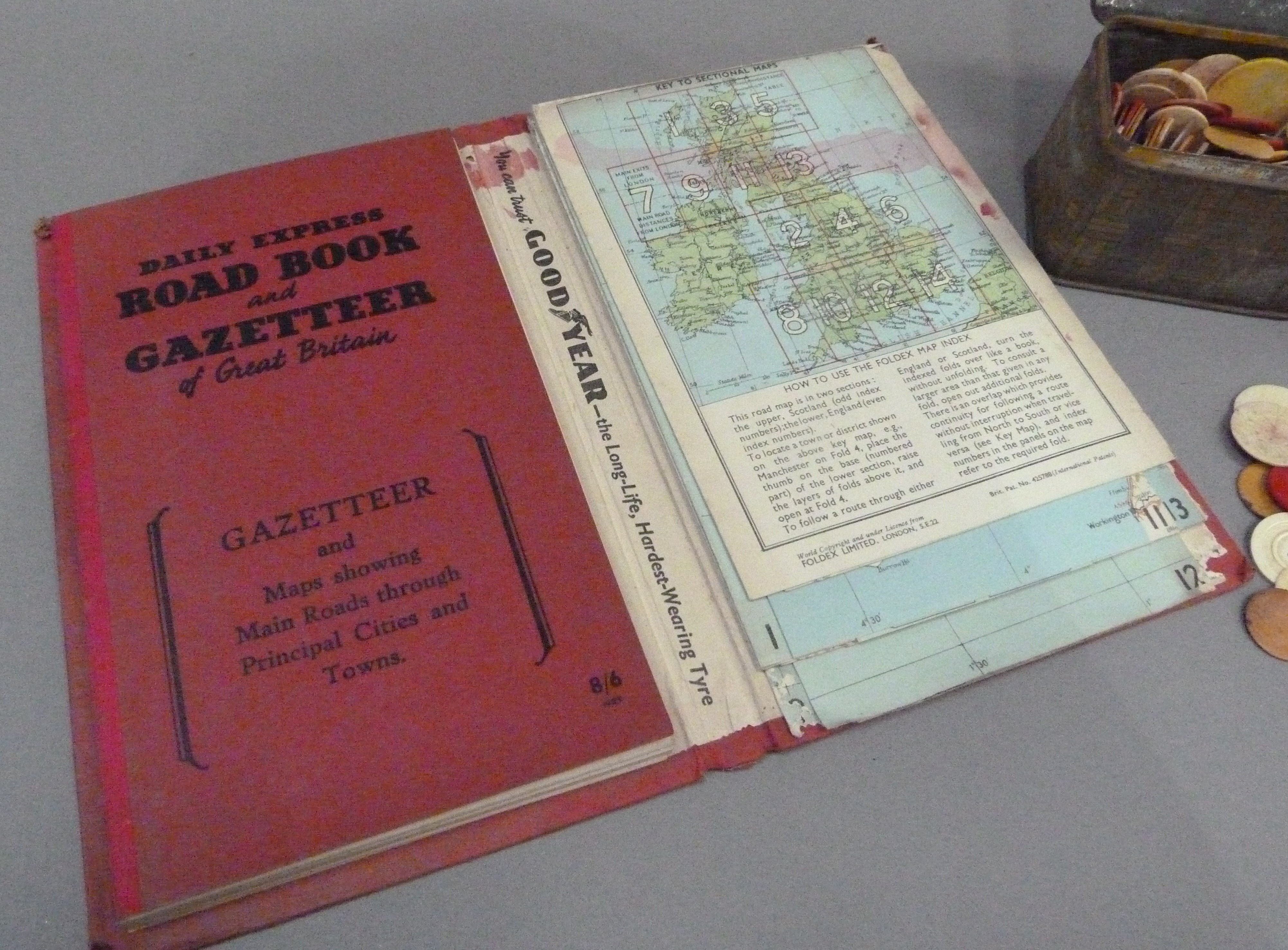 A vintage Daily Express Road Book and Gazetteer together with a tin of plain and coloured counters