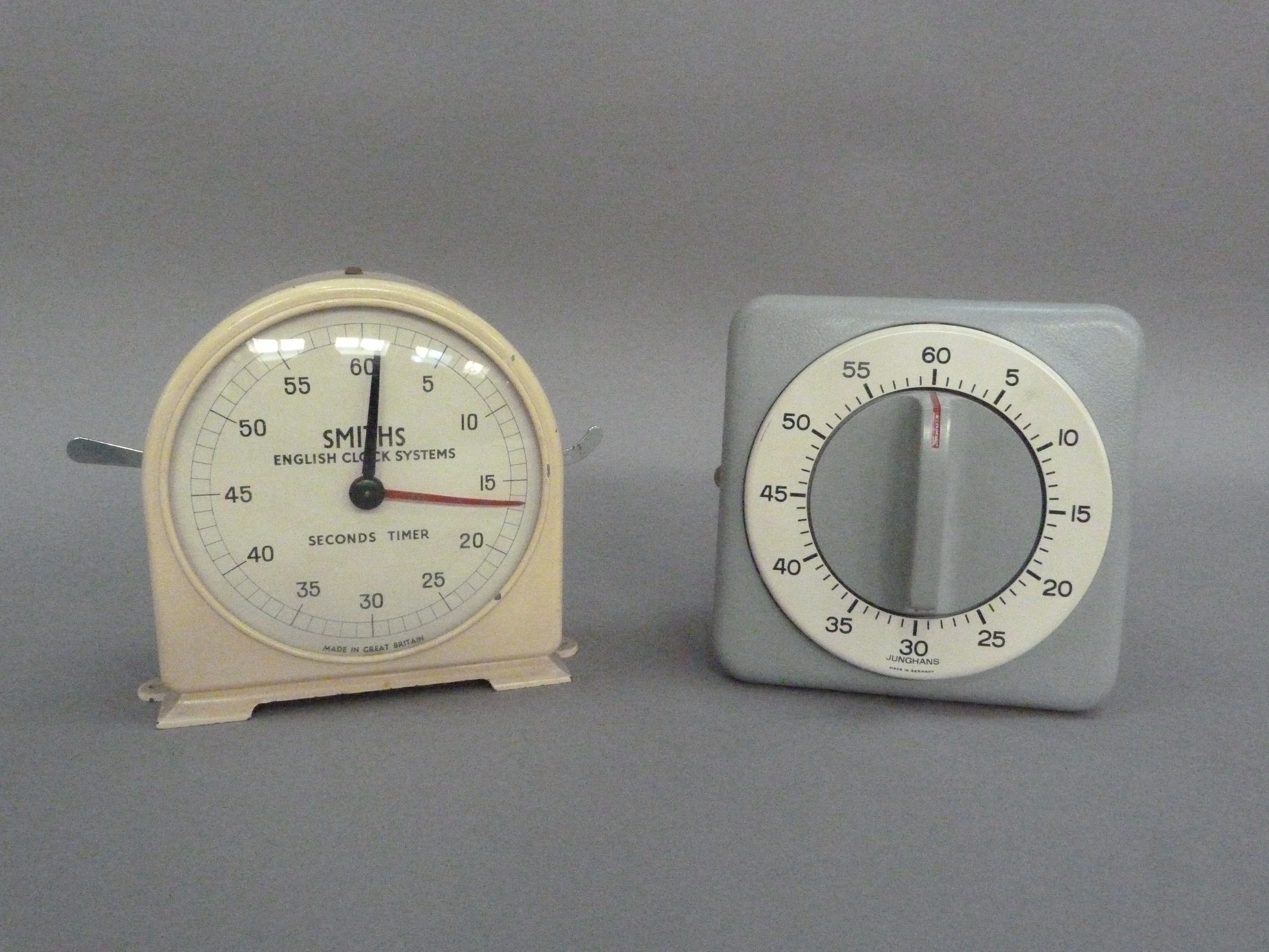 A Smiths Fishing Clock Systems cream metal clock with seconds timer, together with a Junghans