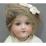 An Armand Marseille bisque headed doll having brown sleeping eyes; open mouth with four teeth,