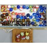 A quantity of vintage marbles to include, red and white opaque, tri-colour swirls, blue with white