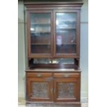A Victorian walnut bookcase, the flared top above pair of glazed upper doors, the mirrored back