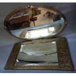 A brass framed wall mirror together with an oxidised silver metal framed bevelled mirror of oval