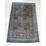 A Persian type rug woven in shades of green, mushroom and brown with panels depicting hanging