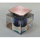 A glass inkwell of square outline with pale pink enamel silver lid, Birmingham 1929, mark rubbed