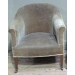 An Edwardian tub shaped armchair upholstered in velvet and on square tapered legs with ceramic