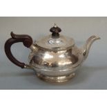 A silver teapot of circular domed outline with egg and dart rim, treen finial and handle, Birmingham