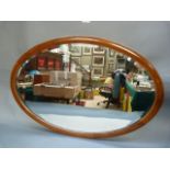 An Edwardian mahogany oval wall mirror inlaid with ebony and boxwood chequered stringing, 79cm x