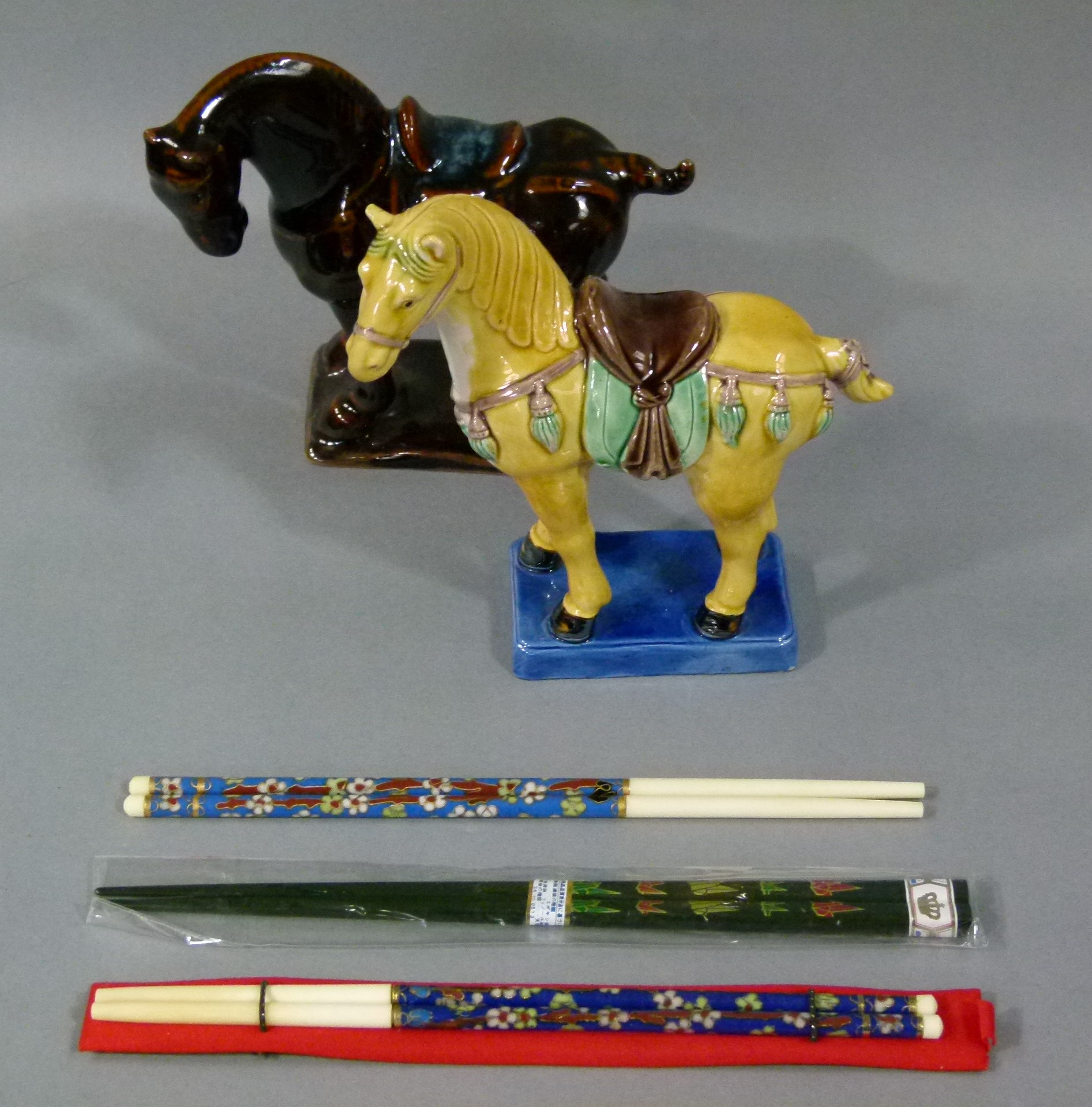 Two pottery Chinese style horse figures, one glazed in yellow, brown, green and on a blue base,