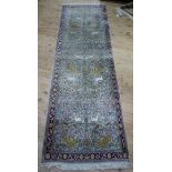 A Persian style rug woven with tigers and deer amongst flowering trees in pale green, pink and blue,