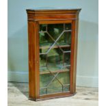 An Edwardian mahogany and glazed single door corner hanging cupboard