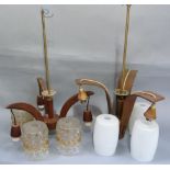 Two teak three branch light pendants, one with white glass shades decorated with stylised leafage,