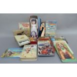 A collection of children's books, building bricks, pixiano toy piano, dolls, and a child's