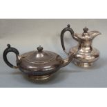 A silver teapot of compressed circular outline on footrim, ebonised handle with a guilloche border