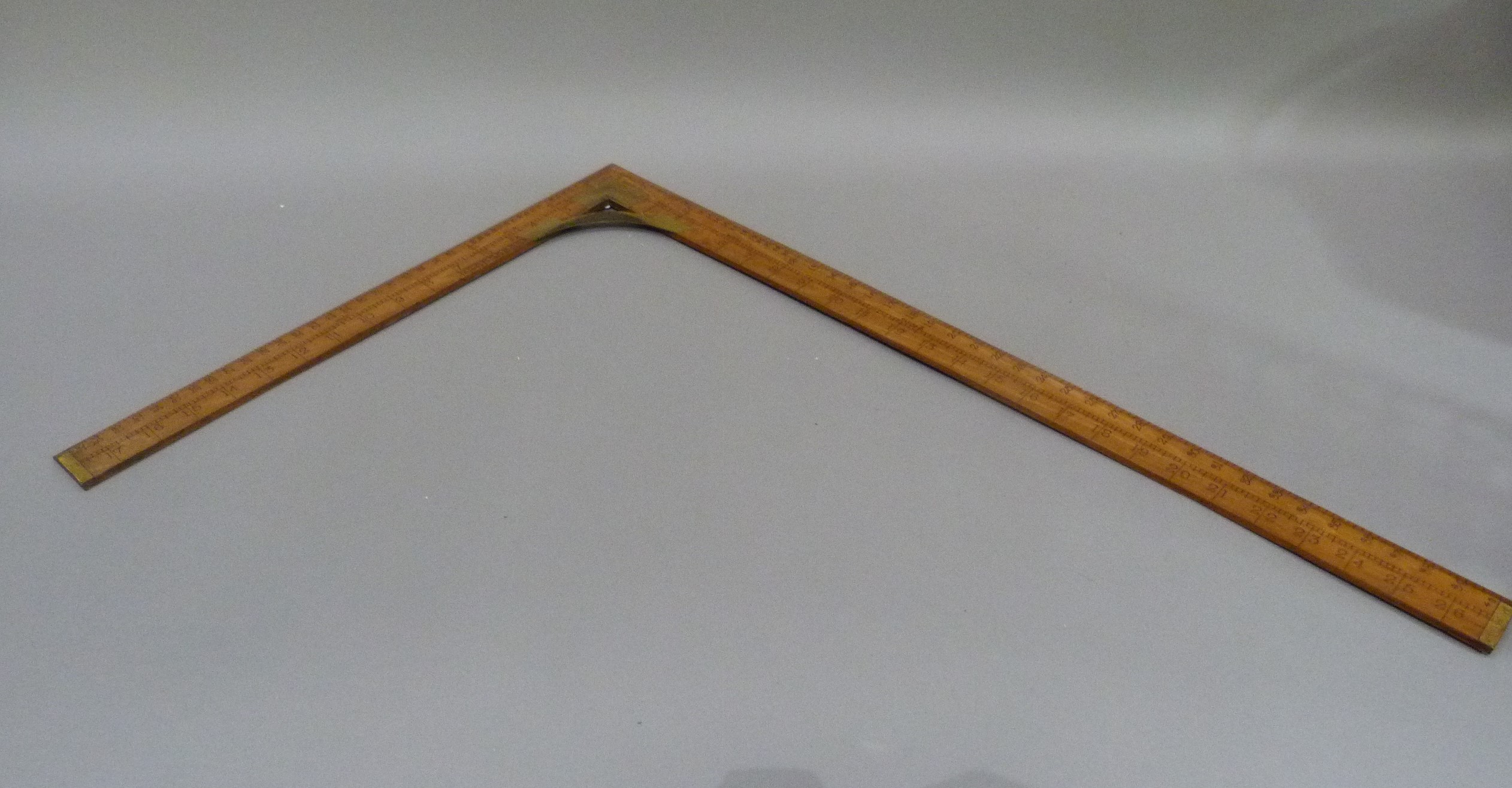 A vintage set square inlaid with brass, measuring 18cm x 27cm