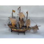 A wooden model of a three masted sailing ship, 76cm long approximately