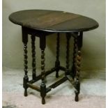 A small oak gateleg table having twin oval drop leaves on slender barley twist and square framing