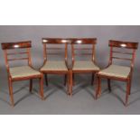 A set of four regency mahogany sabre leg dining chairs with figured concave cresting rails and