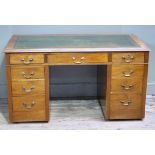 An Edwardian mahogany twin pedestal desk, the rectangular top inset with a gilt tooled green leather