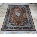 A Persian style rug with a central medallion filled with flowers on a similar field in dark blue,