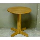 A circular elm table on pedestal base with four fin legs